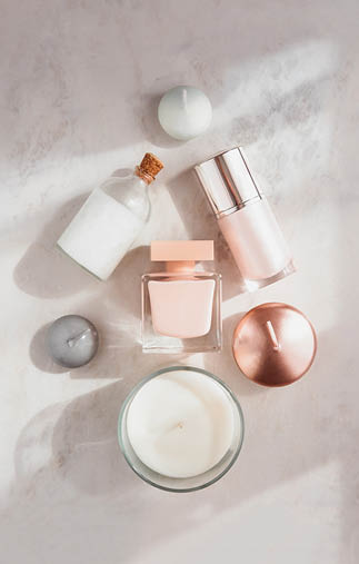 Spa beauty products flatlay in shape of Christmas tree on white marble table  Coconut oil, luxury cream, serum, perfume, candles 