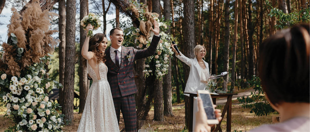 Happy bride and groom after saying YES to each other in front of the wedding arch  Newlyweds at the outside wedding ceremony