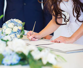 Bride hand with a pen signing wedding license