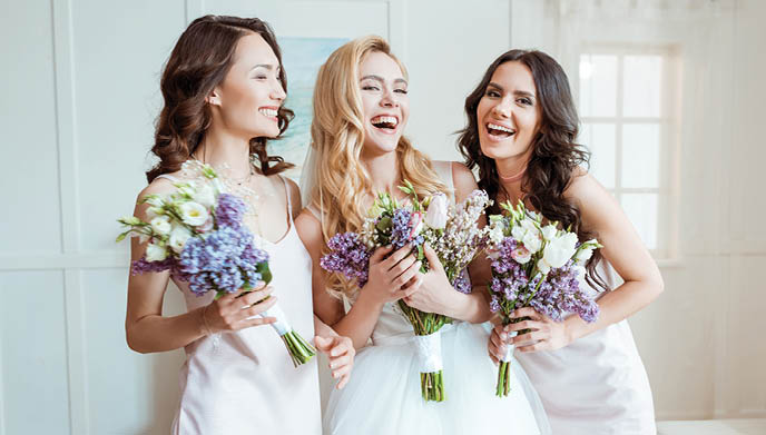 beautiful laughing bride with bridesmaids holding bouquets