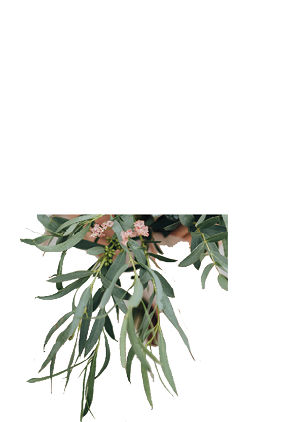 bride in a dress standing in a green garden and holding a wedding bouquet of flowers and greenery