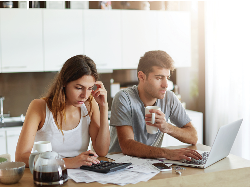 Young couple in love, preparing for their wedding, calculating all expenses, booking cafe over internet using laptop computer, being busy with preparation while sitting at kitchen. Couple paying taxes