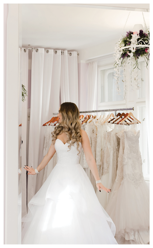 Young woman choosing and try it out wedding dress in store.