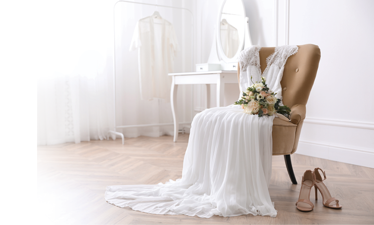 Elegant wedding dress, shoes and bouquet in room