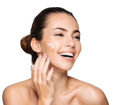 Close up beauty portrait of a laughing beautiful half naked woman applying face cream and looking away isolated over white background