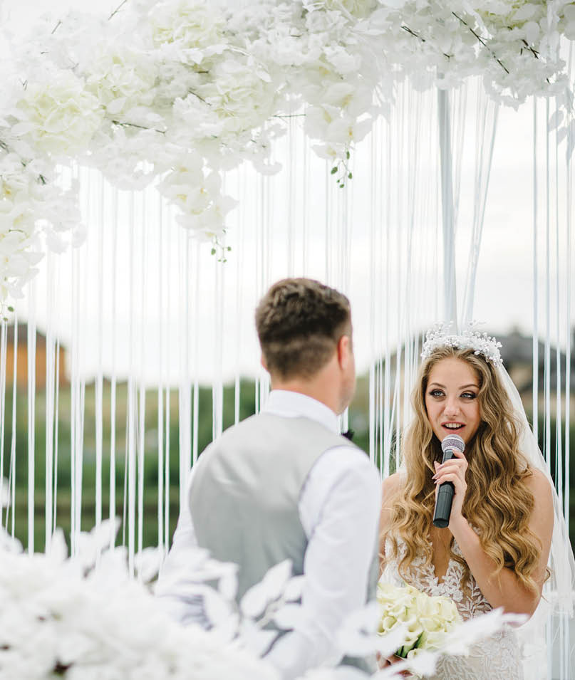 Happy young bride and groom exchanging wedding vows on ceremony  The bride says the promise in the microphone  Fidelity in love 