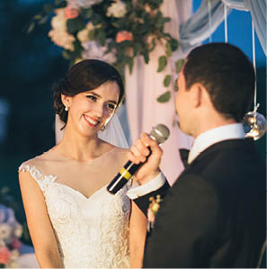 The groom keeps a microphone and speeking to his bride