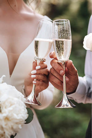 Wedding glasses in hands bride and groom