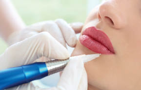 Young woman having permanent makeup on lips in beautician salon