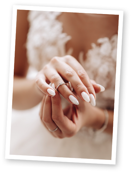 Young and beautiful bride in a white wedding dress sits clasped hands, a ring on the brideâ  s finger 