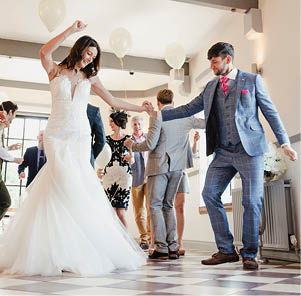 Newly wed couple are enjoying dancing with all of their guests on their wedding day. 
