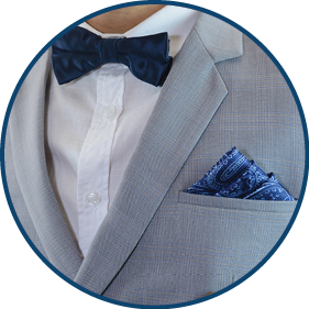 Man in grey suit, plaid texture, blue bowtie and pocket square, close up white background