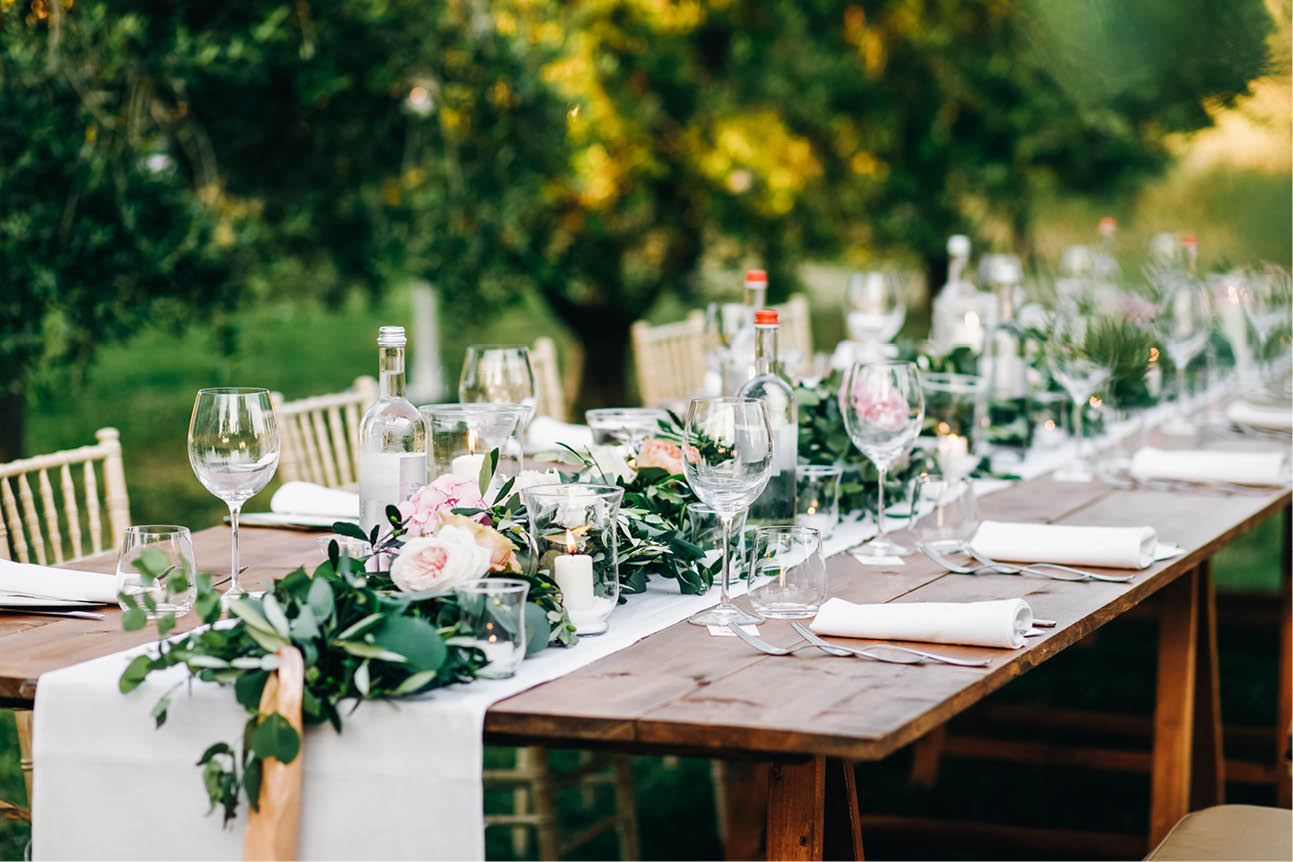 Floral garland of eucalyptus and pink flowers lies on the table for wedding reception  Italian dinner
