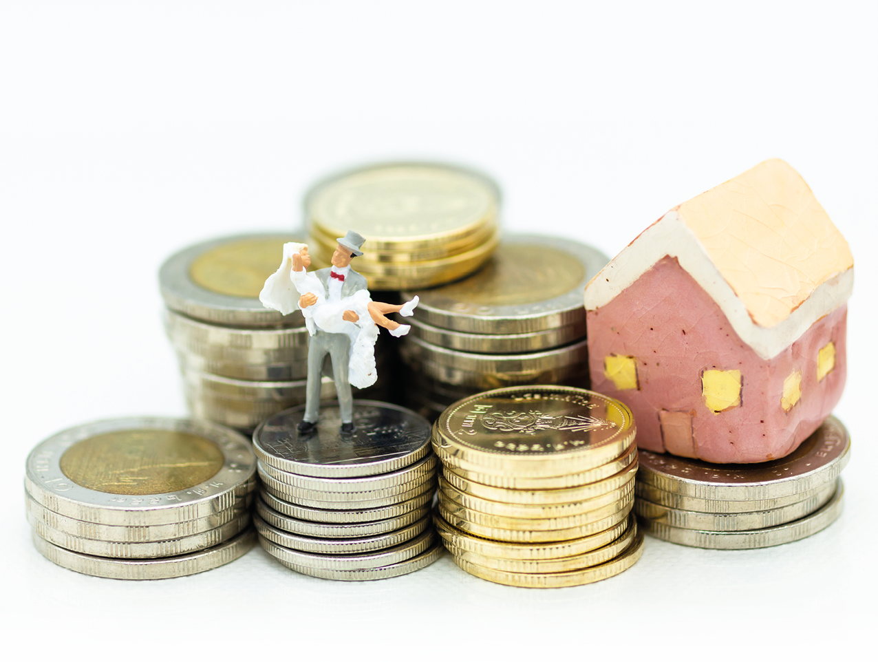 Miniature people : Bride and groom standing on stack of coins with wedding suite  Image use for saving money , accumulate money for the future 