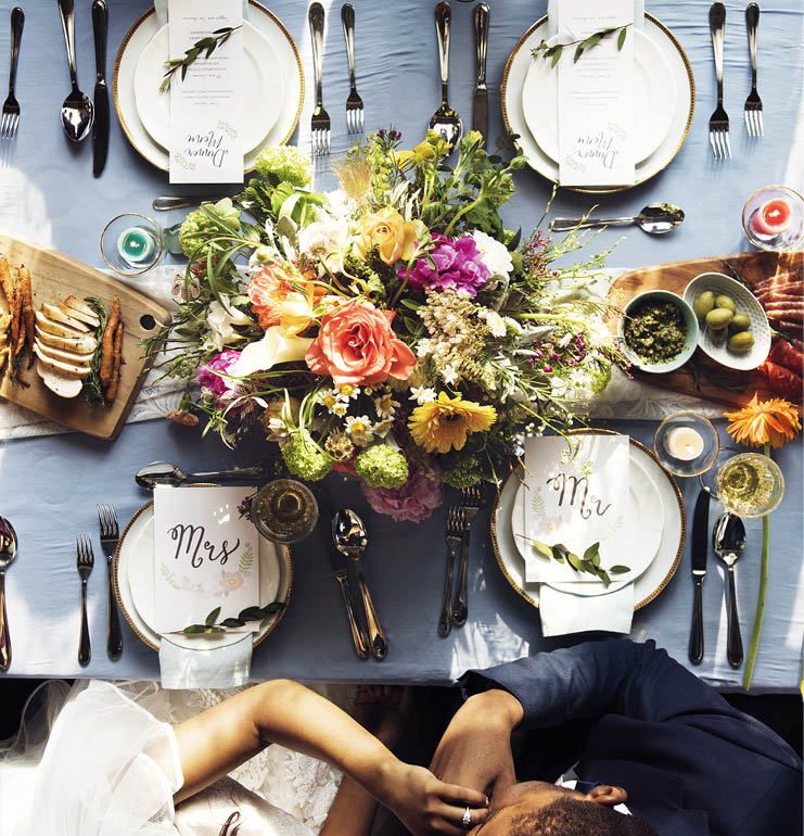 Groom kissing bride hand in wedding reception aerial view