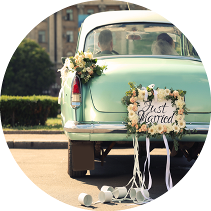 Wedding couple in car decorated with plate JUST MARRIED and cans outdoors