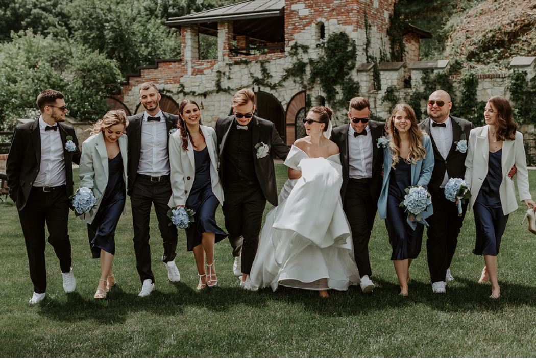 Newlywed couple, bridesmaids and groomsmen having fun outdoors