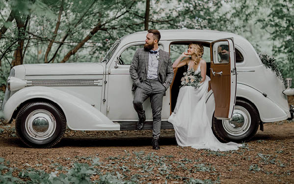 The bearded groom and beautiful bride. Retro car.