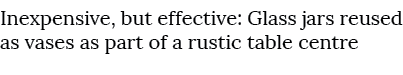 Inexpensive, but effective: Glass jars reused as vases as part of a rustic table centre