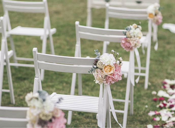 Outgoing wedding ceremony. Decor Studio. white wooden chairs on a green lawn. Wedding festal arch. White armchairs for guests