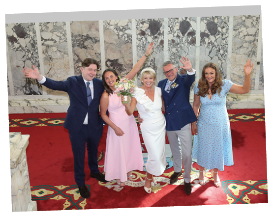 A group of people standing on a red carpet. Description generated by AI