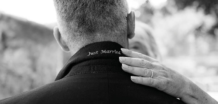 A man wearing a black shirt with the words “just married" on it. Description generated by AI