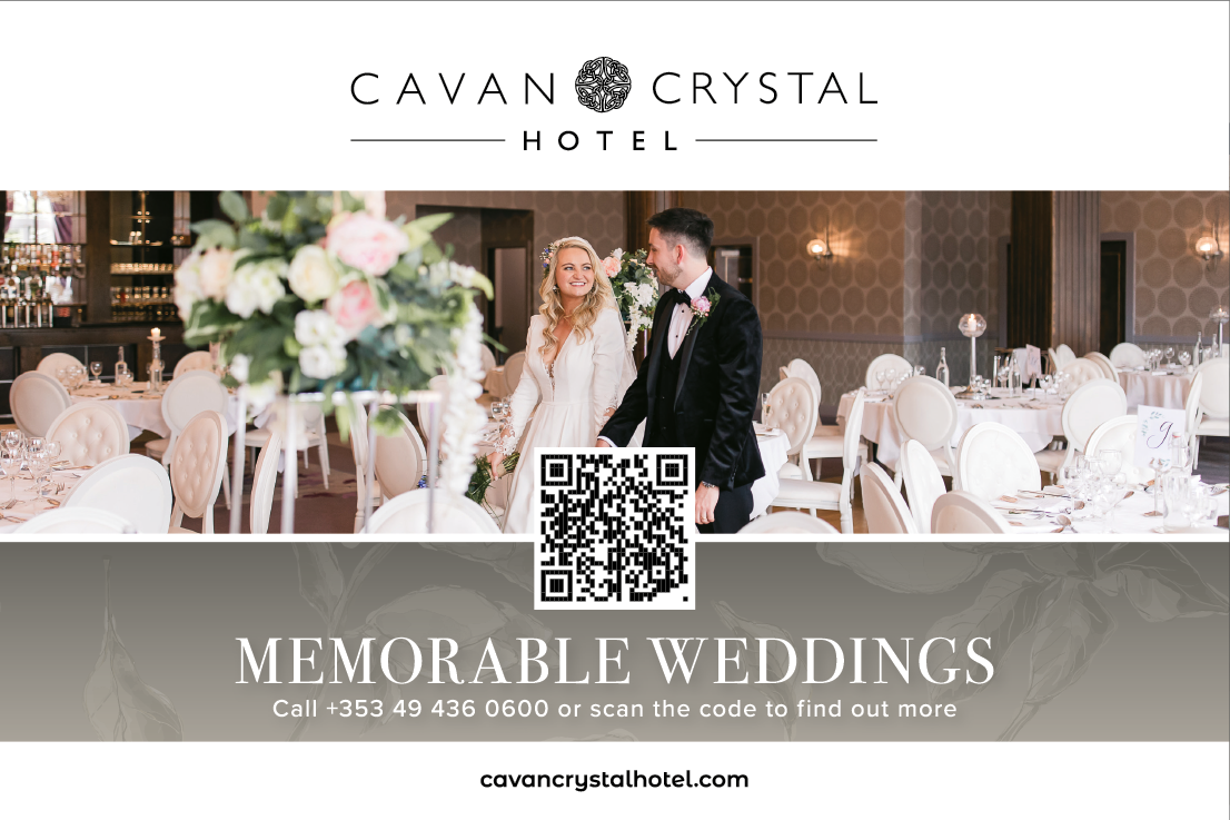 A wedding couple standing in front of a table with a vase of flowers. Description generated by AI