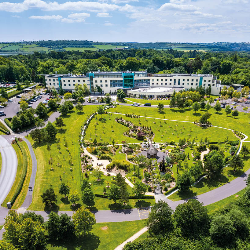 A large green field with a building in the background. Description generated by AI