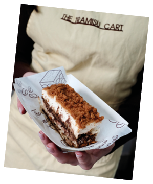 A person holding a piece of cake. Description generated by AI