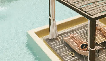 A wooden deck with two lounge chairs and a canopy. Description generated by AI