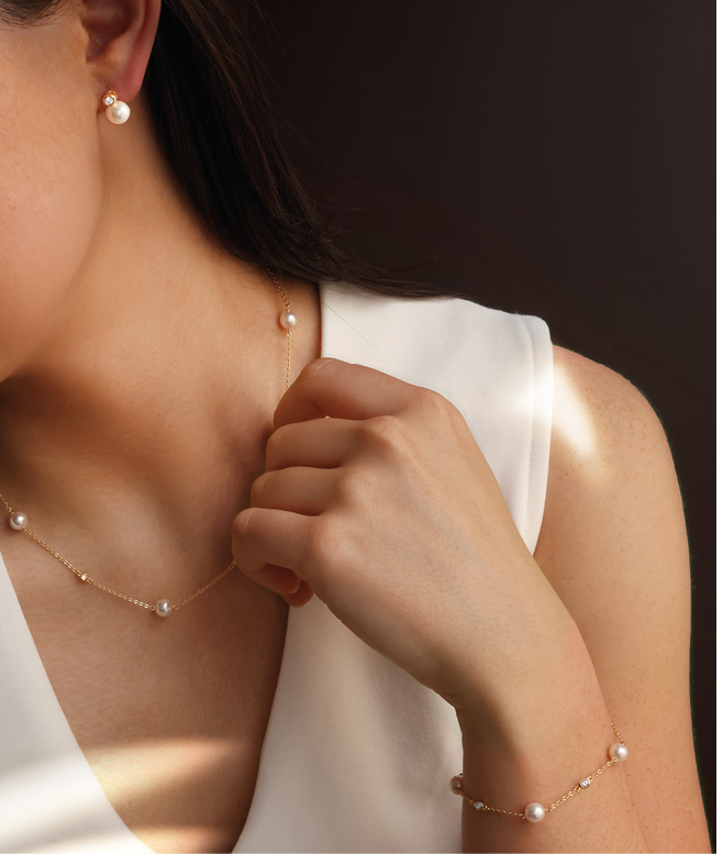 A woman wearing a white shirt and a necklace. Description generated by AI