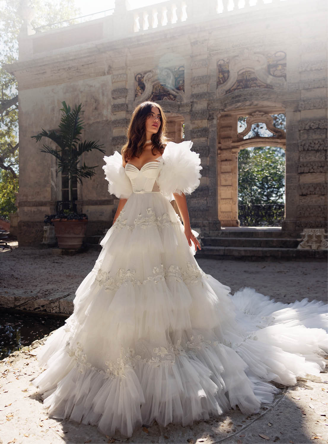 A woman in a white dress with a train. Description generated by AI