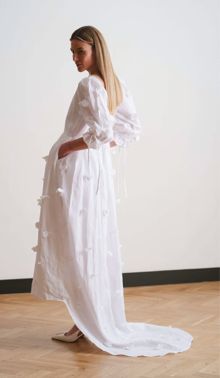A woman wearing a white dress. Description generated by AI