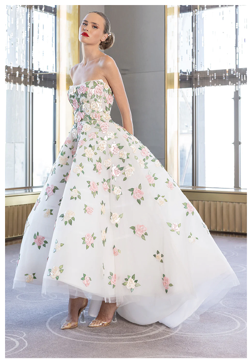 A woman in a white dress with a floral pattern. Description generated by AI