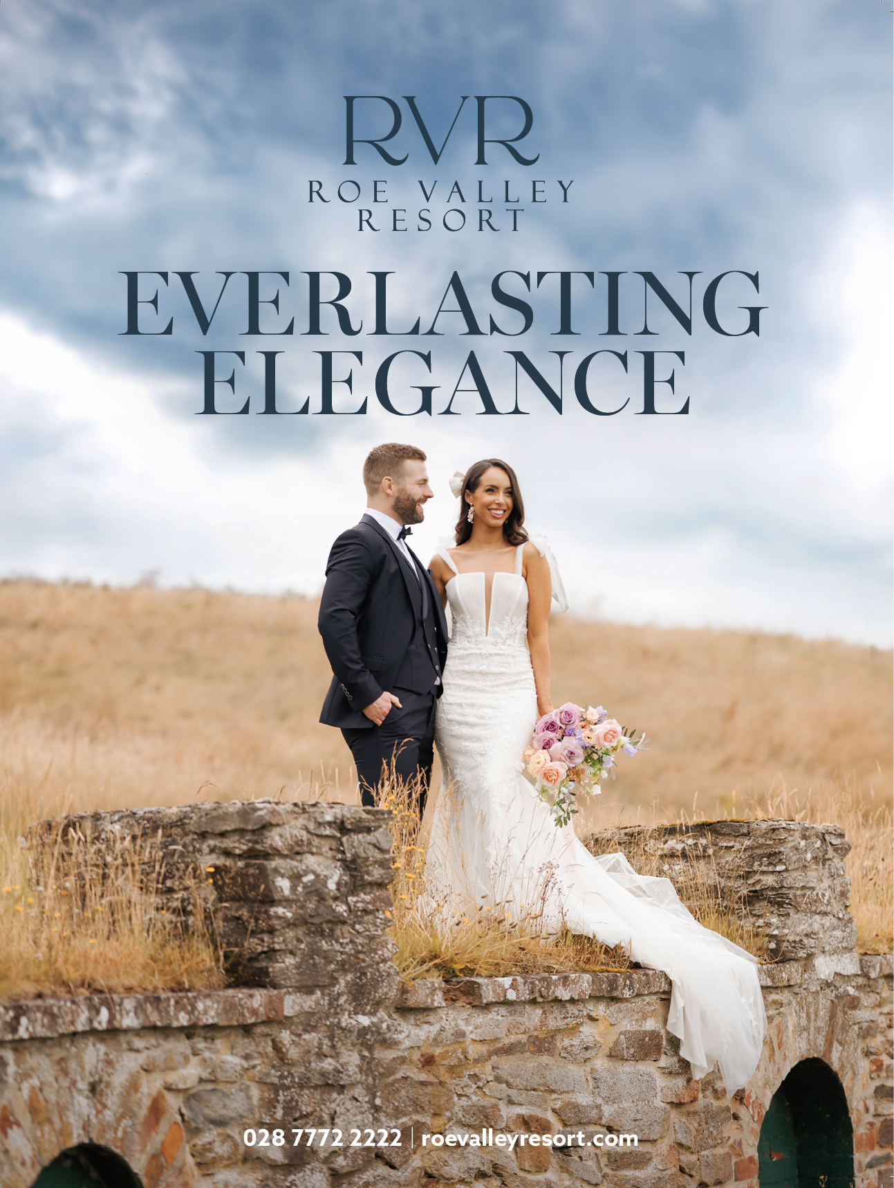 A bride and groom standing on a brick wall. Description generated by AI