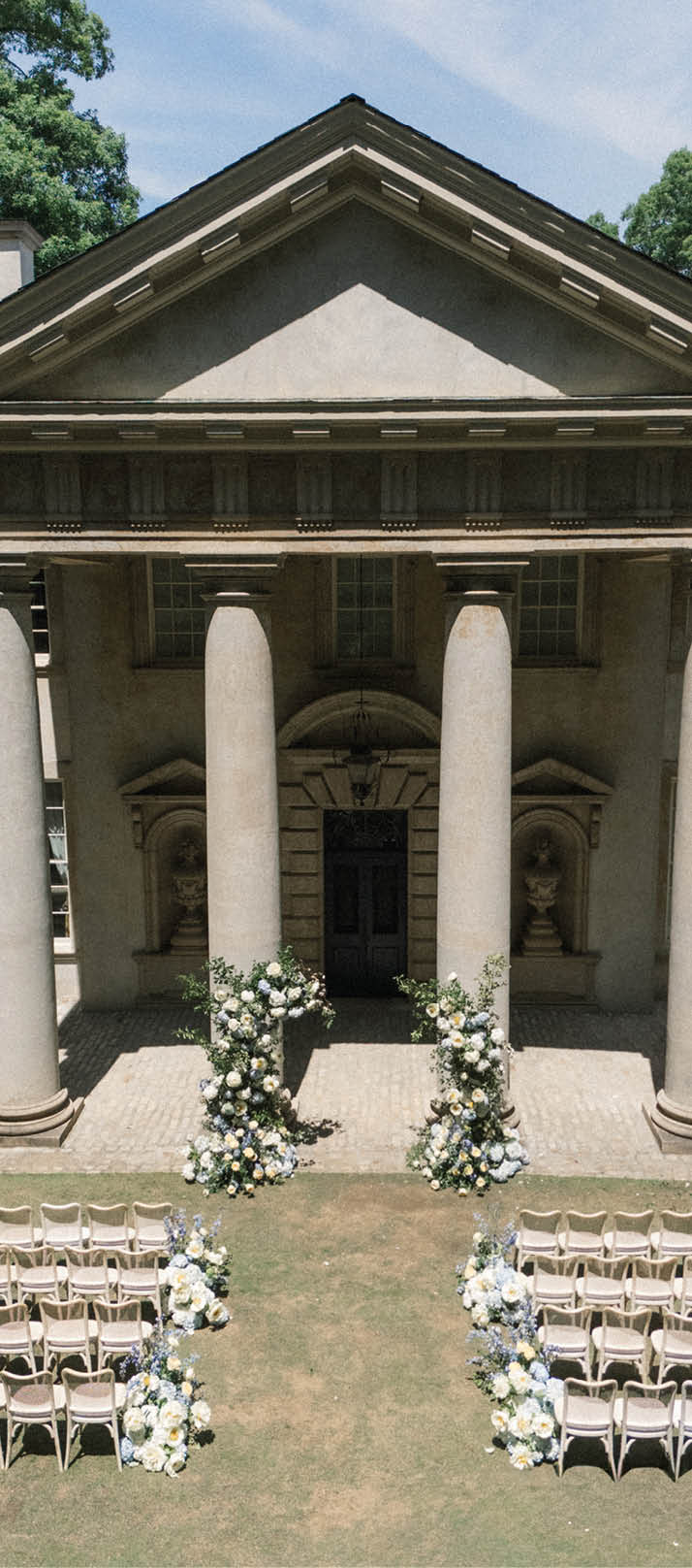 A large building with columns and a white roof. Description generated by AI