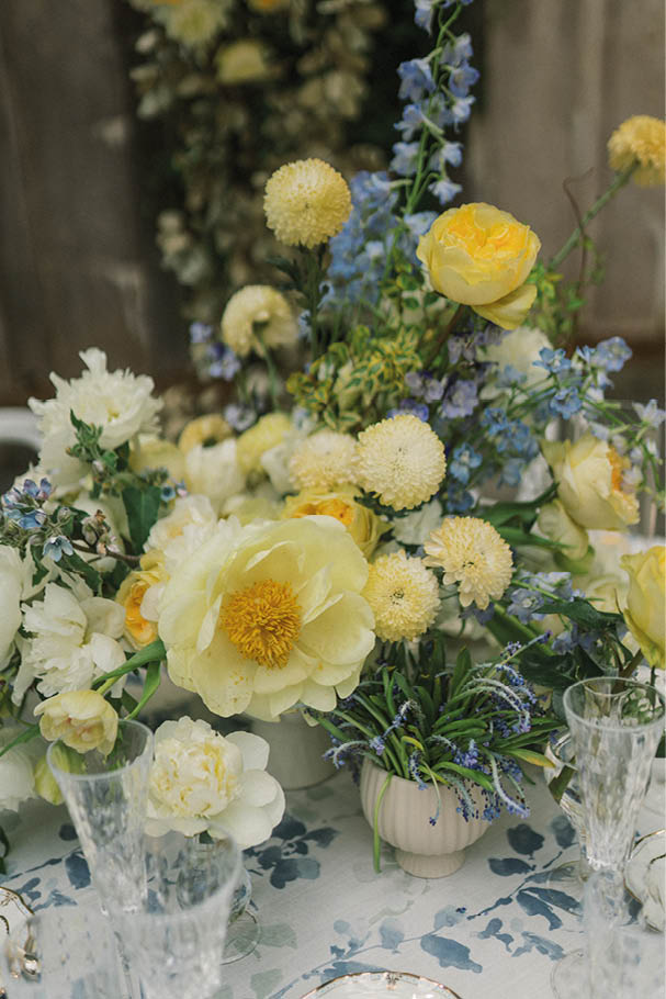 A table with a vase of flowers and wine glasses. Description generated by AI