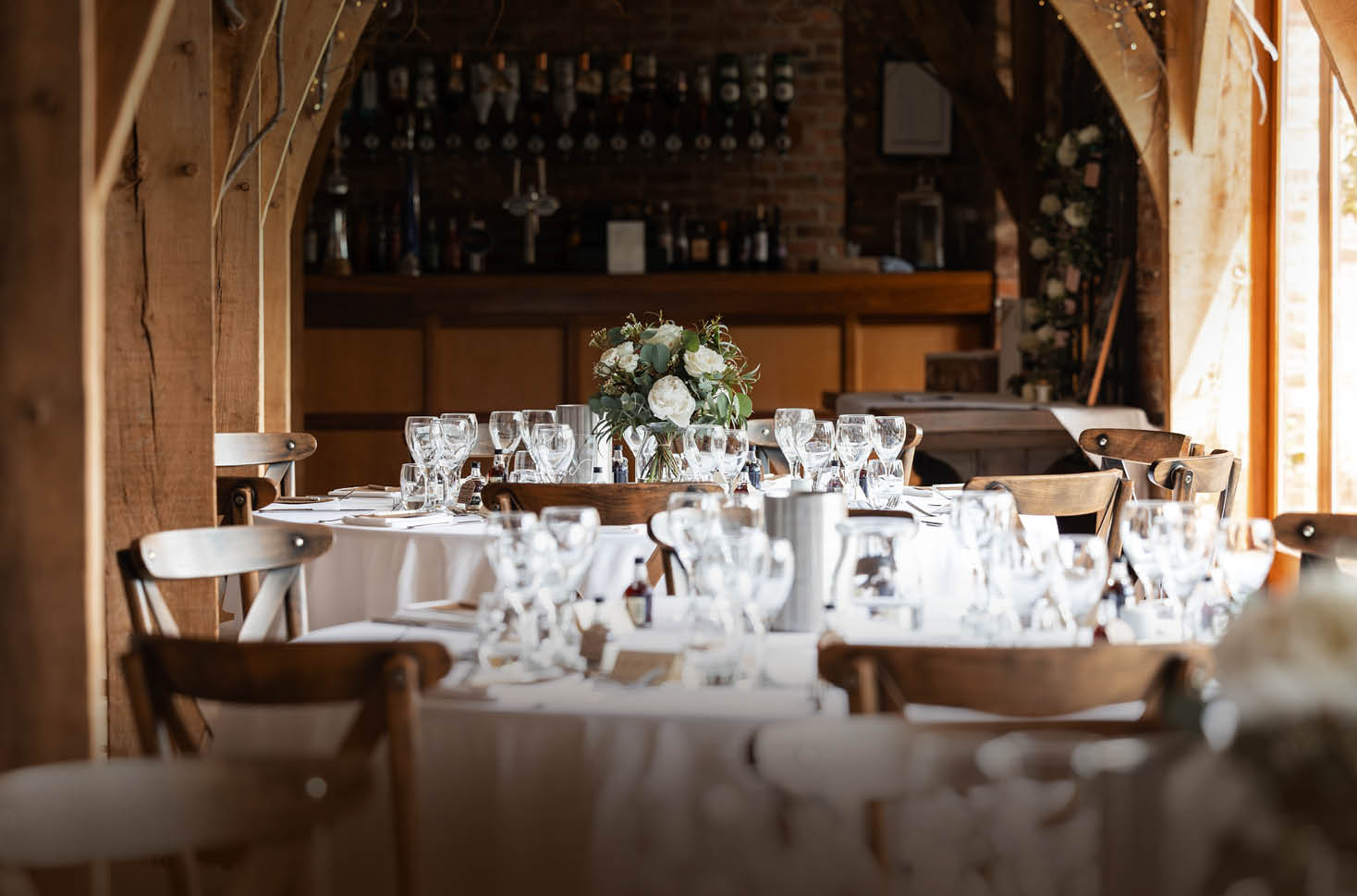 A table with a white tablecloth and wine glasses. Description generated by AI
