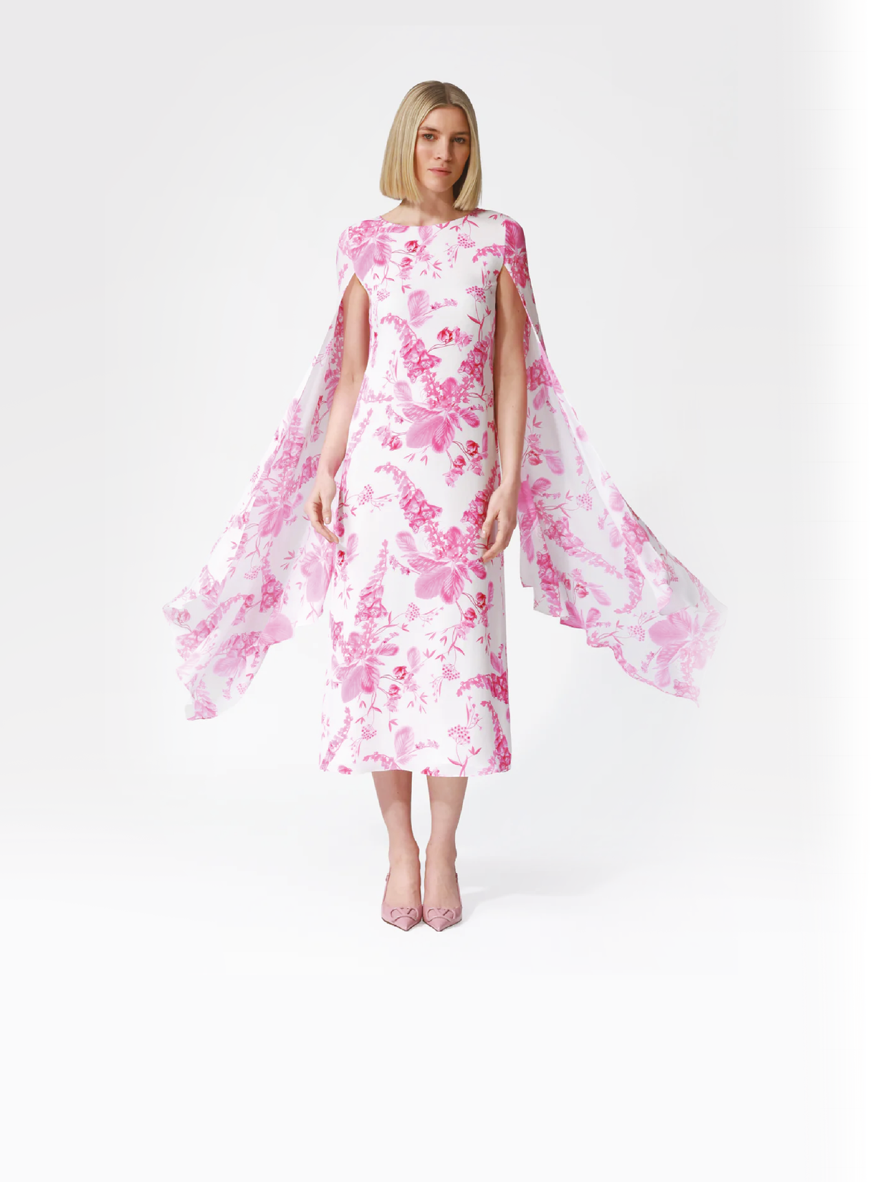 A woman wearing a dress with a pink and white floral pattern. Description generated by AI