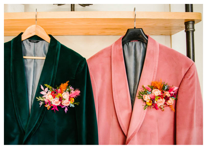 Two men's jackets are hanging on a rack. Description generated by AI