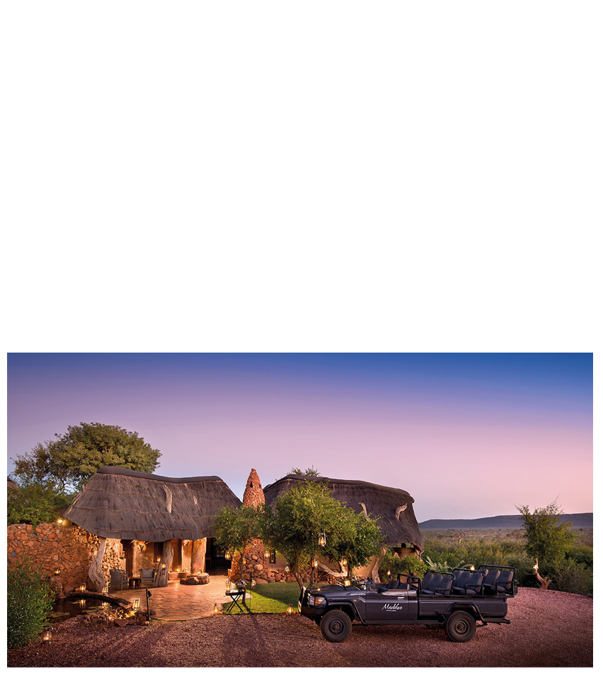 A black truck is parked in front of a hut. Description generated by AI