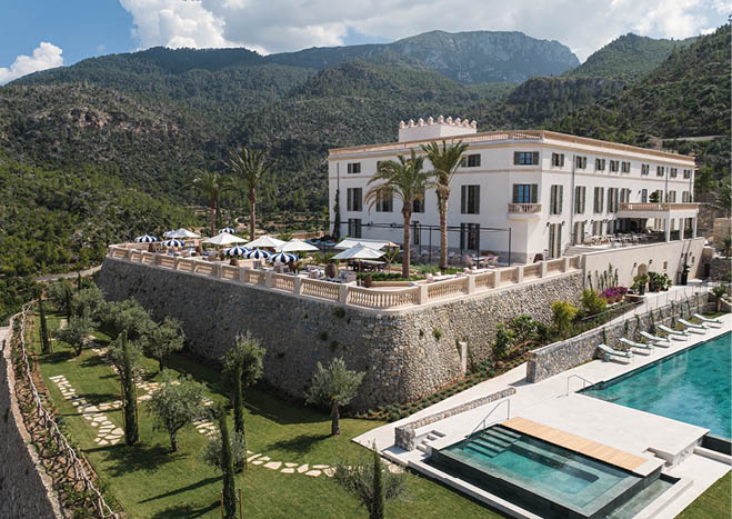 A large white building with a pool in front of it. Description generated by AI