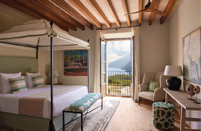 A bedroom with a bed, a chair, a table, and a painting. Description generated by AI