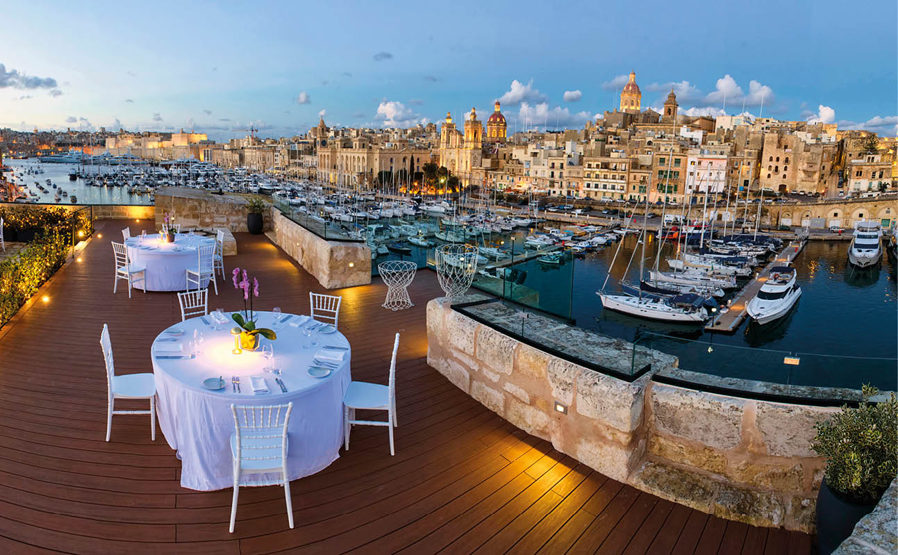 A wooden deck overlooking a marina with several boats. Description generated by AI