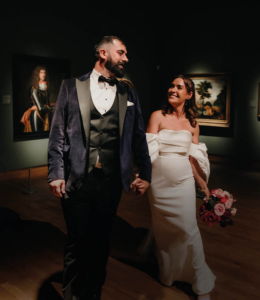 A man and woman walking in a dark room. Description generated by AI