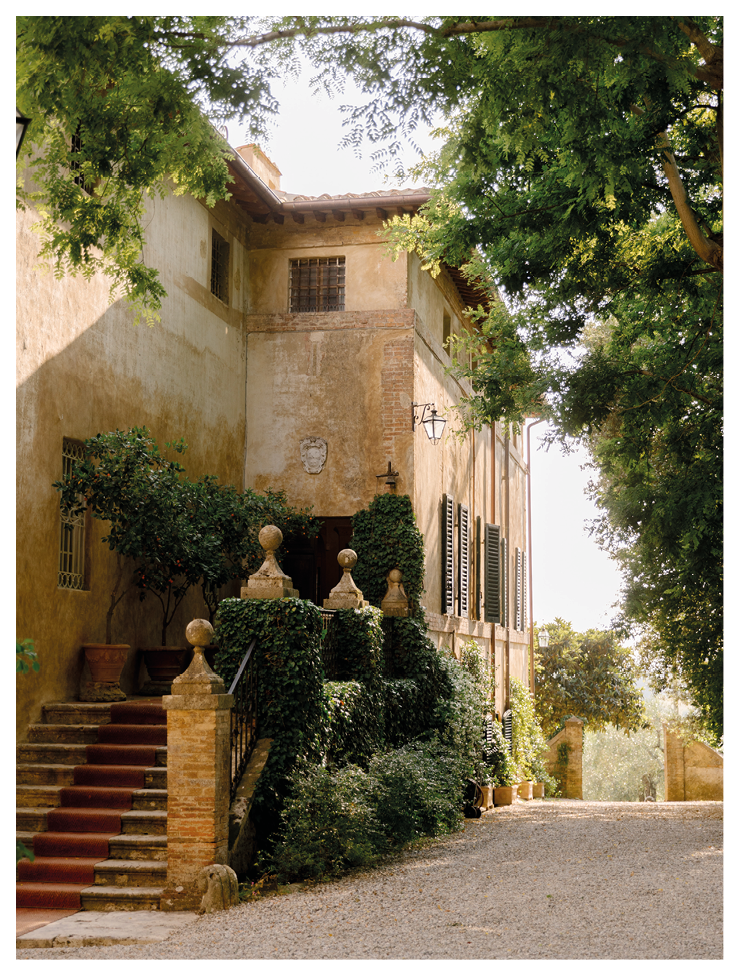 A large house with a red staircase and a green bush in front. Description generated by AI