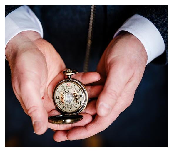 A man is holding a pocket watch. Description generated by AI