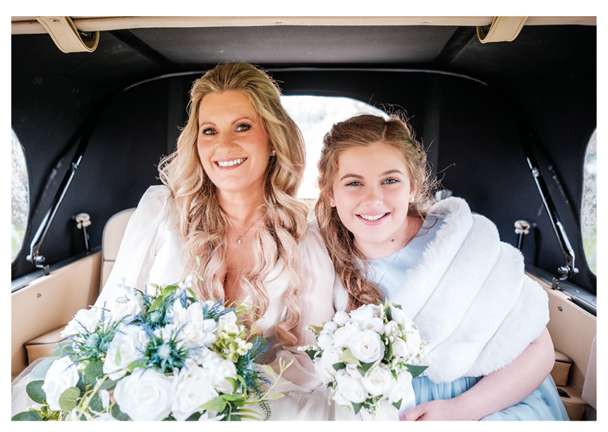A bride and a young girl are sitting in a car. Description generated by AI