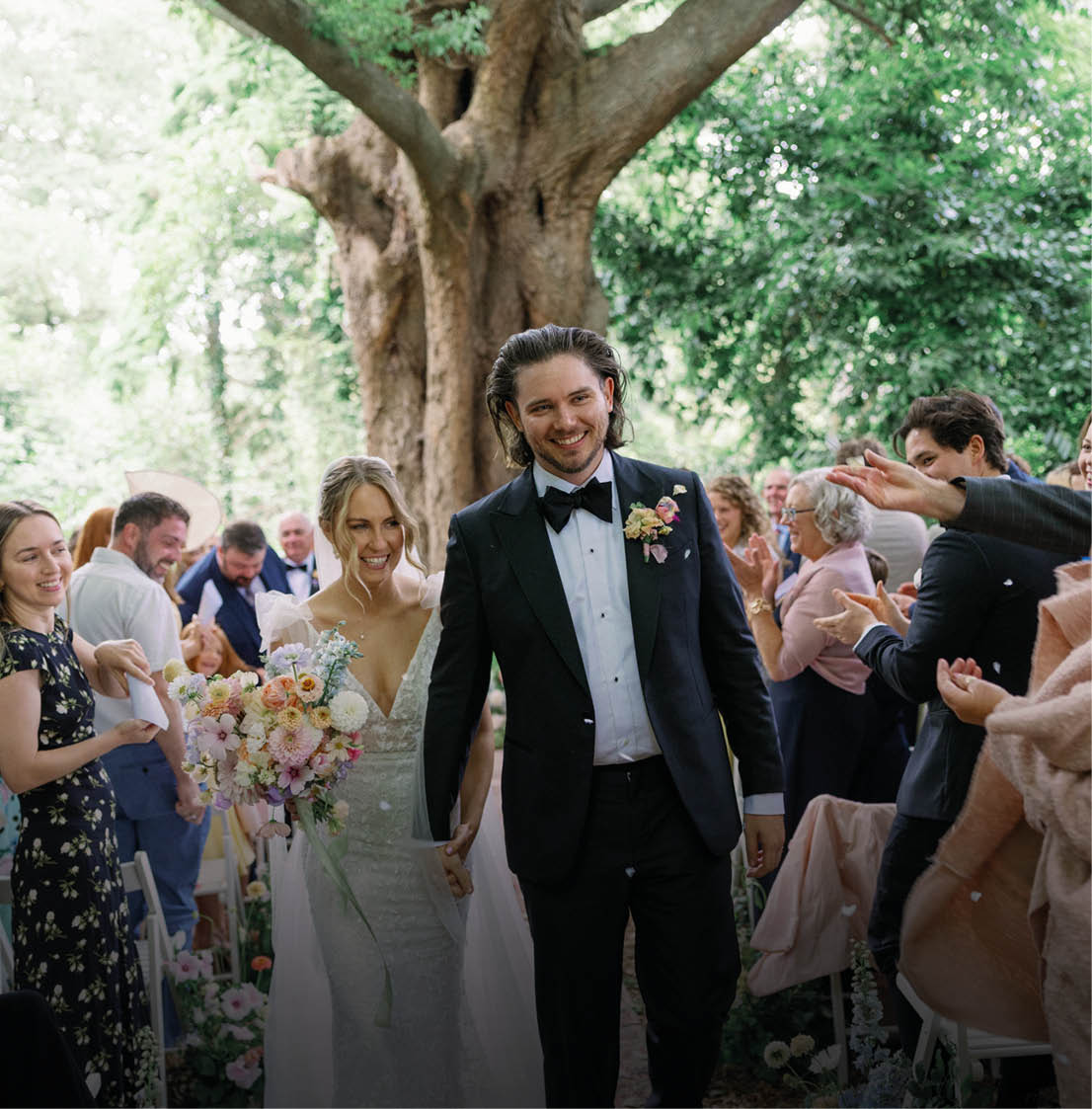 A bride and groom are walking down the aisle. Description generated by AI