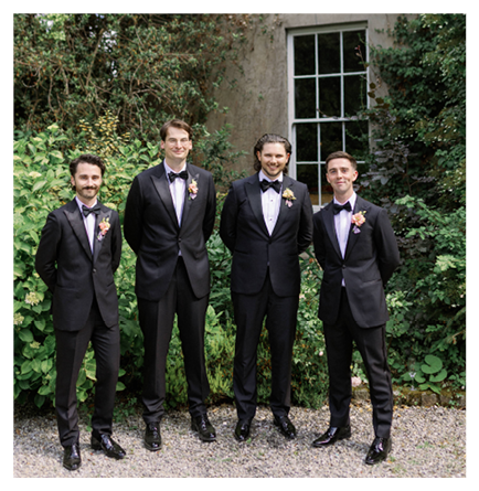 Four men wearing suits and ties. Description generated by AI